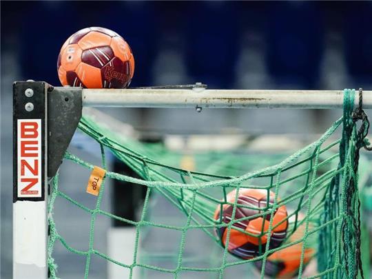 Spielbälle liegen im Netz eines Handball-Tors. Foto: Uwe Anspach/dpa/Symbolbild