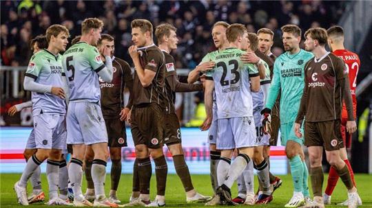 Spieler beider Mannschaften stehen nach dem Abpfiif auf dem Platz.