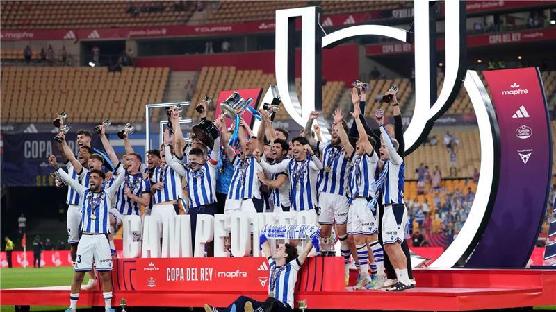 Spieler von Real Sociedad feiern mit dem Pokal.