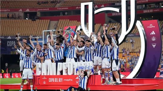 Spieler von Real Sociedad feiern mit dem Pokal.