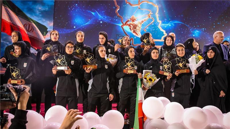 Spielerinnen der iranischen Fußball-Nationalmannschaft stehen auf einer Bühne in Teheran, während einer Empfangszeremonie nach ihrer Teilnahme am AFC Women’s Asian Cup in Australien.