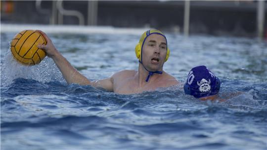Wasserballer Nils Trimborn schwimmt im Wasser und setzt zum Wurf an.