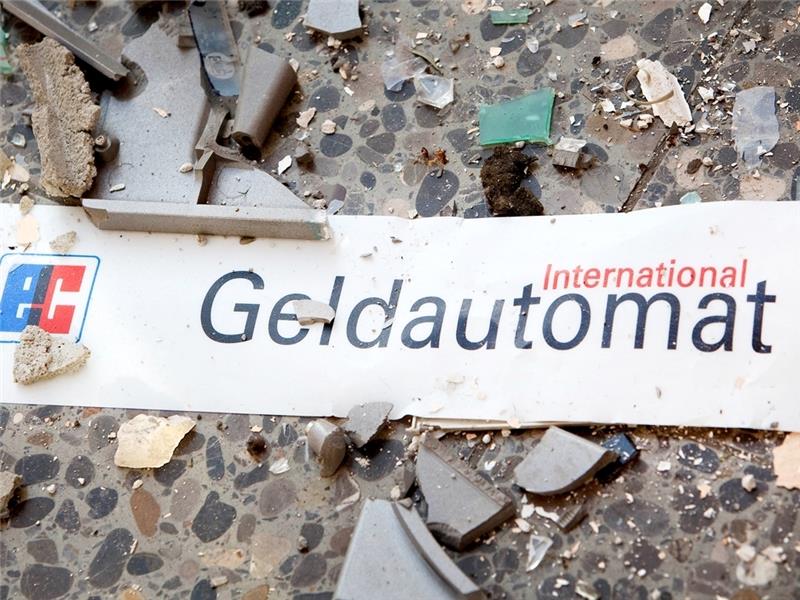 Splitter und ein Schild mit der Aufschrift „Geldautomat“ liegen auf dem Fußboden vor einem gesprengten Geldautomaten. Foto: dpa