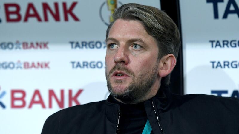 Sportdirektor von Münster, Peter Niemeyer, sitzt auf der Bank.