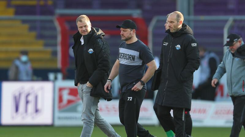 Sportgeschäftsführer Fabian Wohlgemuth (l-r), Trainer Steffen Baumgart und Co-Trainer Daniel Scherning aus Paderborn gehen über das Spielfeld.