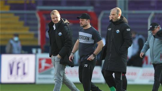 Sportgeschäftsführer Fabian Wohlgemuth (l-r), Trainer Steffen Baumgart und Co-Trainer Daniel Scherning aus Paderborn gehen über das Spielfeld.