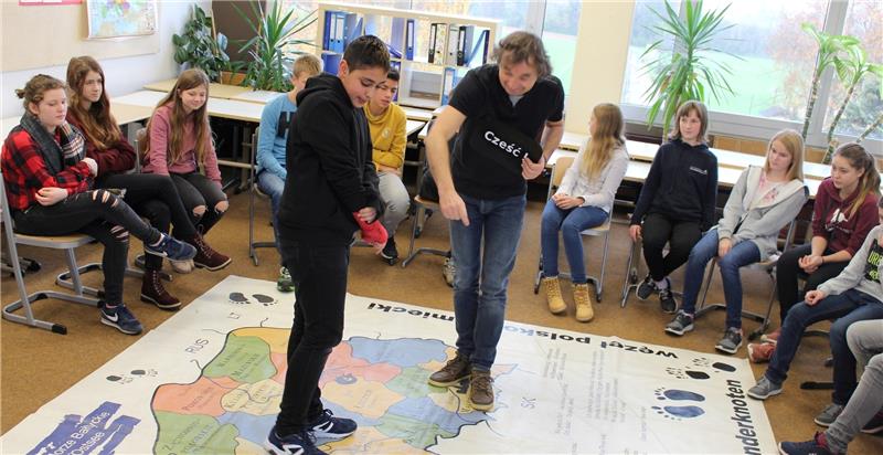 Sprachanimateur Marius Flunt zeigt Mohammed aus der Klasse 7b, wo er auf der großen Karte, die Deutschland und Polen mit ihren Bundesländern und Provinzen zeigt, gerade steht. Foto Richter