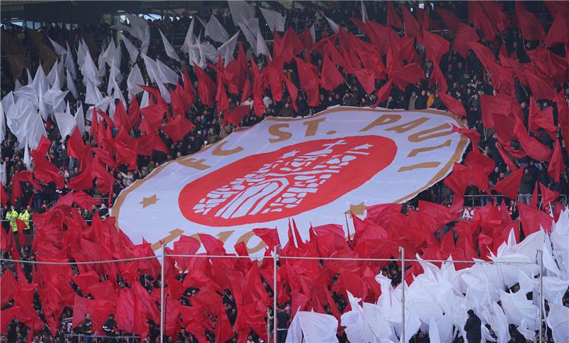 St. Pauli Fans halten ein riesiges Vereinslogo vor Spielbeginn hoch. Der Club ruft zum zweiten autofreien Spieltag auf. Foto: Marcus Brandt/dpa