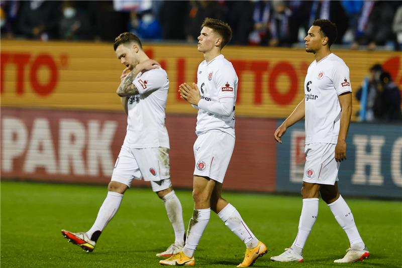 St. Paulis Christopher Buchtmann (l-r), Finn Ole Becker und Etienne Amenyido reagieren enttäuscht nach der Niederlage in Kiel. Foto: Frank Molter/dpa