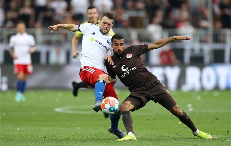 St. Paulis Daniel-Kofi Kyereh (rechts) im Duell mit Jonas Meffert vom HSV. Foto: Christian Charisius/dpa