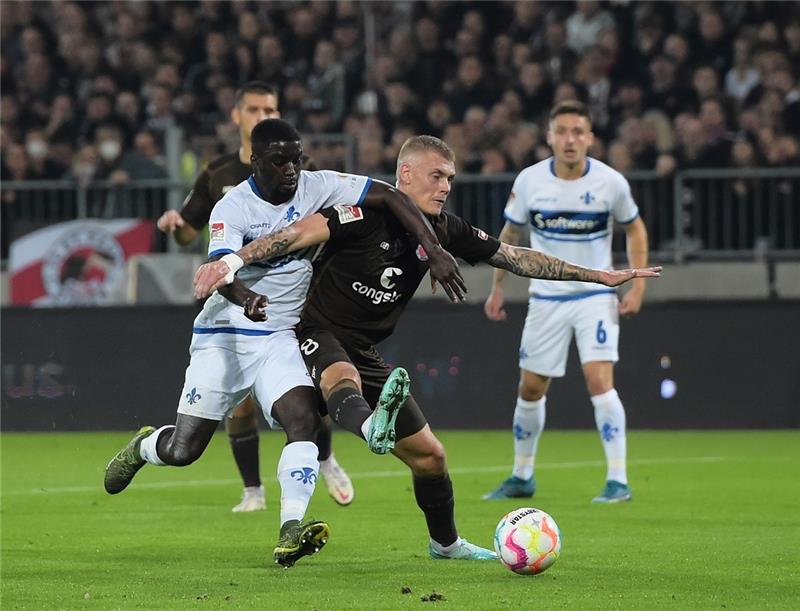 FC St. Pauli ringt Tabellenführer Darmstadt ein Remis ab St. Paulis Eric Smith schirmt den Ball gegen Darmstadts Braydon Manu (l) im eigenen Strafraum ab. Foto: Gregor Fischer/dpa
