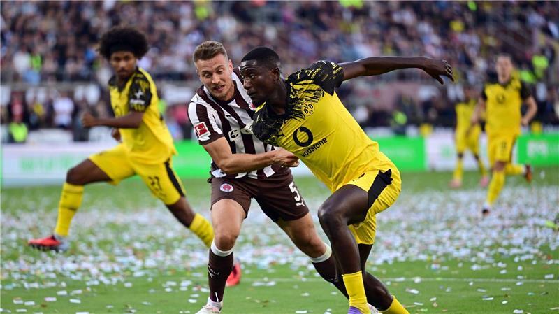 3:3-Spektakel: BVB gibt Sieg bei St. Pauli aus der Hand St. Paulis Hauke Wahl (l) im Zweikampf mit BVB-Stürmer Serhou Guirassy.