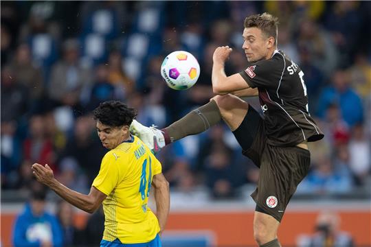 St. Paulis Hauke Wahl (r) und Braunschweigs Johan Gomez kämpfen um den Ball.