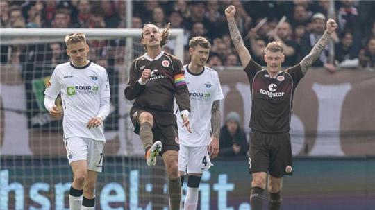 St. Paulis Jackson Irvine (2.v.l) und St. Paulis Eric Smith (r) feiern beim Abpfiff.