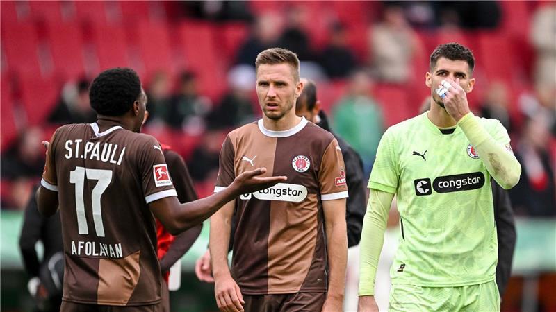 St. Paulis Karol Mets (M) und Torwart Nikola Vasilj (r) verlassen den Club im Sommer. (Archivbild)