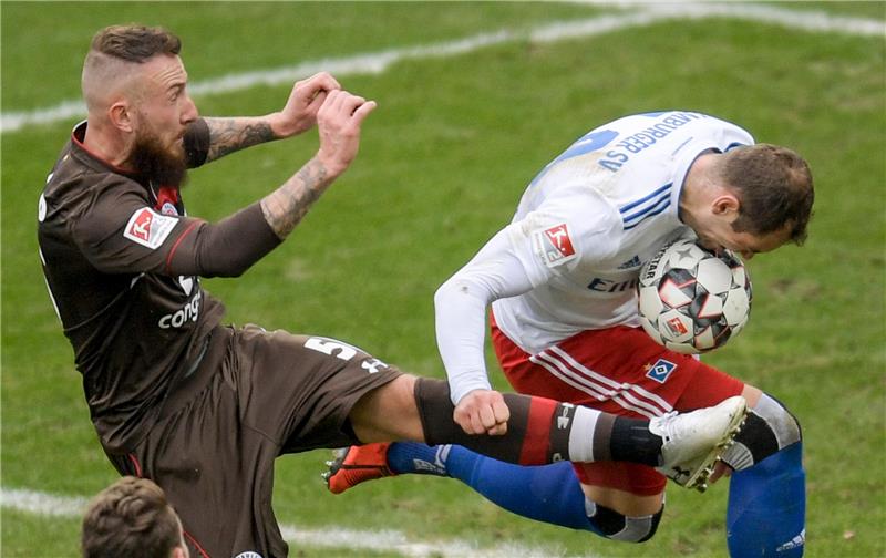 St. Paulis Marvin Knoll (links im Bild) und HSV-Spieler Pierre-Michel Lasogga kämpfen um den Ball. Recrop. Foto: Axel Heimken/dpa