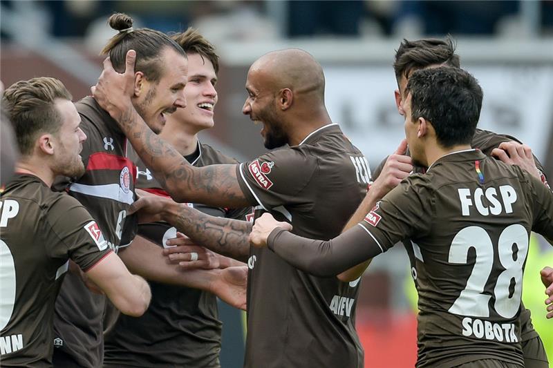 St. Paulis Spieler feiern Alex Meier (M) für seinen Treffer zum 1:0. Foto: Axel Heimken/dpa
