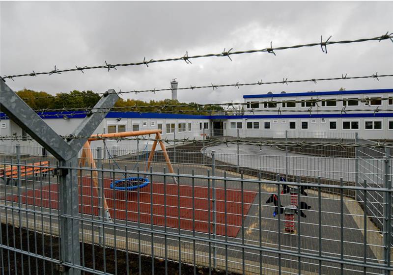 Stacheldraht umgibt die Container des Ausreisegewahrsams am Hamburger Flughafen. Foto: Axel Heimken/dpa 