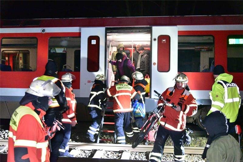 Stader Feuerwehrleute und Polizisten evakuieren die Passagiere der S-Bahn, die kurz vor dem Bahnhof Stade liegengeblieben ist. Fotos: Beneke