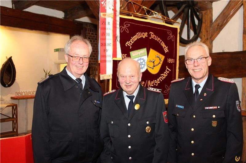 Stadtbrandmeister Horst Meyer und Kreisbrandmeister Peter Winter nehmen den Jubilar Otto Marquardt in ihre Mitte. Foto: Felsch
