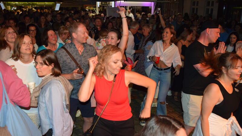 Weinfest in Buxtehude: Hier feiern Tausende Menschen zu Rock’n’Roll Stadtfest mit Weindörfern - so lässt sich das Weinfest in Buxtehude beschreiben. Vor der Bühne auf dem Petri-Platz tanzen die Menschen ausgelassen zu Cover-Rocksongs von der Band Les Amies.