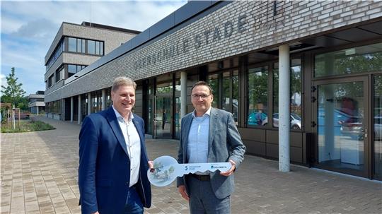 Stadtrat Carsten Brokelmann (links) erhält von Carsten Hense, Geschäftsführer der Firma Goldbeck, den symbolischen Schlüssel für den Bildungscampus. Foto: Hansestadt Stade