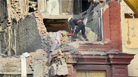 Städtische Arbeiter räumen Trümmer aus einem Wohnhaus, das am 18.10.2023 von einer Rakete getroffen wurde.
