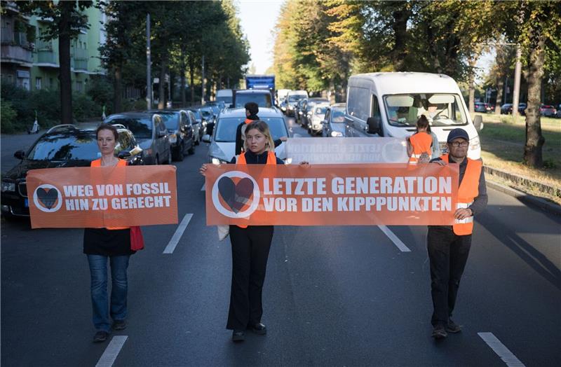 Erneut Klimaproteste in Berlin - Haftstrafe für Aktivistin Statt sich auf die Straße zu setzen oder festzukleben, hielten Demonstrantinnen und Demonstranten heute ogenannte Laufblockaden ab und gingen mit Bannern vor dem Verkehr her.