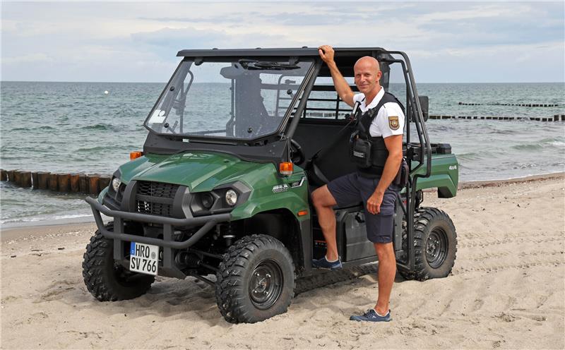 Stefan Bischoff, Strandvogt, steht mit seinem Buggy am Ostseestrand. Gemeinsam mit Polizei, Tourismuszentrale, Stadtforstamt und Stadtamt informiert er, wie sie in diesem Jahr an der Küste der Hansestadt kontrollieren und schützen wollen. Foto: Bernd Wüstneck/dpa +