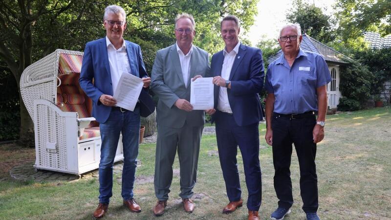 Stellvertretend für alle teilnehmenden Kommunen, Gemeinden und Verbände: Der unterschriebene Pakt in den Händen (von links) von Jürgen Peters (Bürgermeister Gemeinde Neuharlingersiel), Uwe Santjer (Oberbürgermeister Cuxhaven), Holger Heymann (Landrat Kreis Wittmund) und Dirk Sander (Präsident Landesfischereiverband).