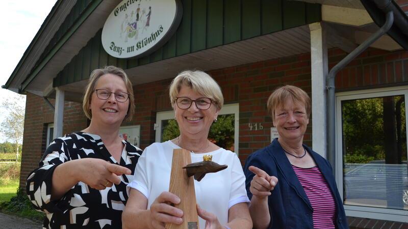 Auszeichnung: Sie erschufen Engelschoffs Dorfmittelpunkt Stellvertretend für den Tanzkreis Engelschoff präsentieren Britta Nagel, Kirsten Stüven-Diercks und Ulrike Weber (von links) den Goldenen Hecht vor der „Danz- un Klönstuv“ .