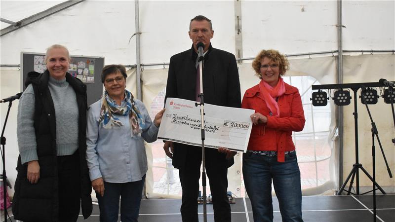 Stimmen verstummen: Einer der ältesten Vereine im Landkreis Stade aufgelöst Checkübergabe auf einer Bühne mit drei Frauen und einem Mann.