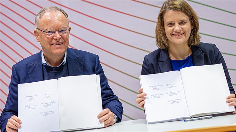 Was SPD und Grüne in Niedersachsen angehen wollen Stephan Weil (SPD) und Julia Willie Hamburg (Bündnis 90/Die Grünen) zeigen den Koalitionsvertrag von SPD und Grünen in Niedersachsen, nachdem sie diesen unterzeichnet haben. Foto: Moritz Frankenberg/dpa