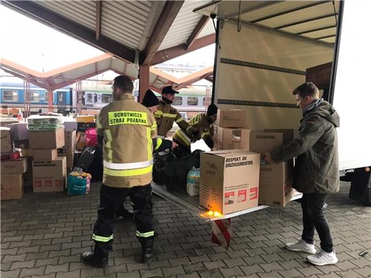 Steven Hermeling (rechts) und polnische Helfer laden am Grenzbahnhof Przemysl Hilfsgüter aus Stade direkt am Gleis zur Verteilung ab. Foto: Hermeling