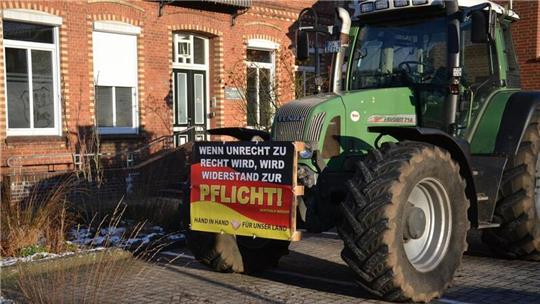 Stiller Protest am Landvolkhaus in Zeven. Die Aufschrift des Plakats ruft bei Passanten Kritik hervor.Foto: Kratzmann