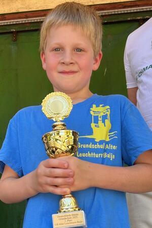 Stolz auf seine Schule: Piet hält den Pokal für die Fitteste Grundschule Deutschlands ganz fest.