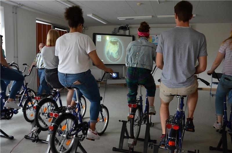 Strampeln für die Leinwand: Schüler erzeugen mit dem „Fahrradkino“ des Unternehmens RegionalEnergie Elbe-Weser den Strom für eine Videoprojektion. Fotos: Husung