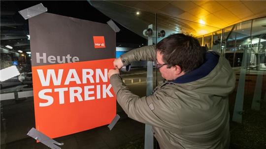 Streikende hängen Plakate mit der Aufschrift „Warnstreik“ bei der Lufthansa Technik auf. Mit erneuten Warnstreiks gleich mehrerer Berufsgruppen legt die Gewerkschaft Verdi am Donnerstag und Freitag wichtige Teile des deutschen Luftverkehrs lahm.