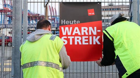 Streikende stehen am Container Terminal Burchardkai (CTB) im Hamburger Hafen zusammen.