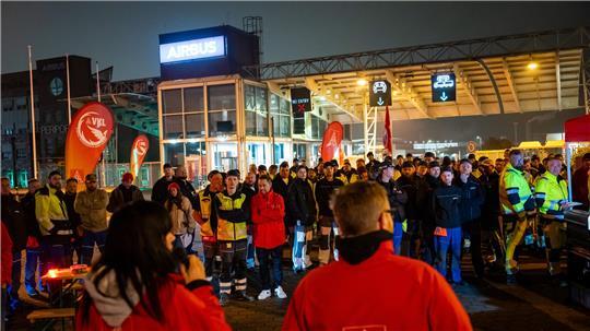 Streikende stehen vor dem Werksgelände von Airbus in Finkenwerder.