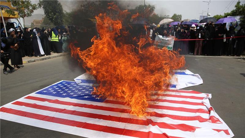 Studenten verbrennen US-amerikanische und israelische Flaggen während einer Kundgebung an der Universität Sanaa im Jemen.