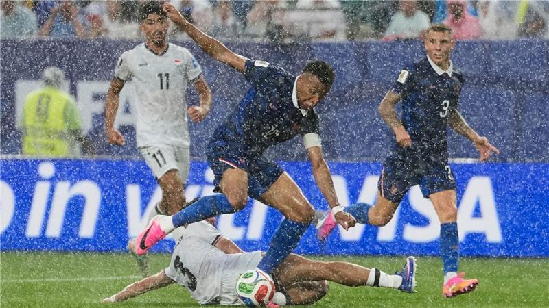 Stürmerstar im Regen: Frankreichs Kylian Mbappé im Zweikampf mit dem Iraker Hussein Ali.