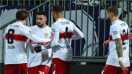 Stuttgarts Deniz Undav (M) feiert mit den Teamkollegen Angelo Stiller (l) und Josha Vagnoman nach seinem Tor zum 1:0 in Kiel.