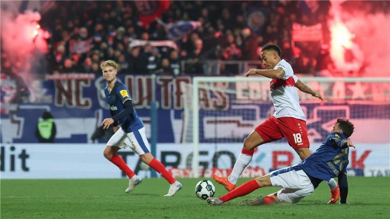 Stuttgarts Jamie Leweling und Kiels Jonas Meffert (r) kämpfen um den Ball. 