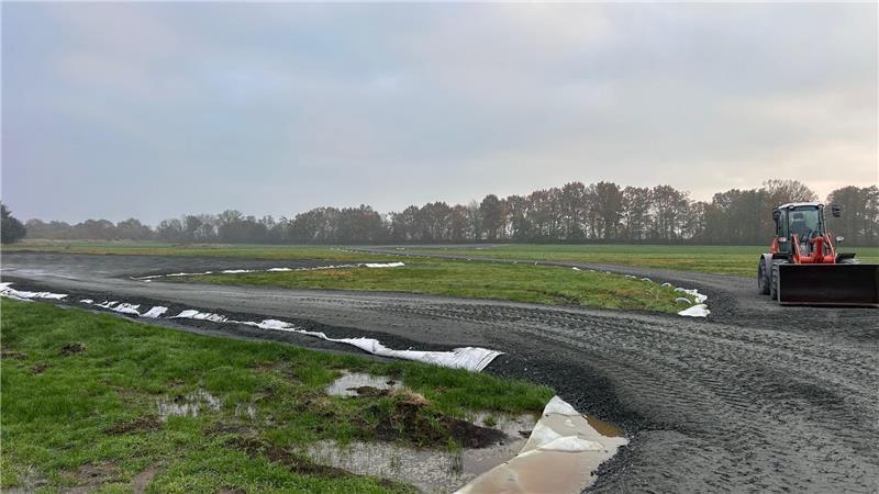 Suedlink-Baustelle in Burweg: Ein festes Vlies trennt Schotter und Grünland. Die Baumreihe im Hintergrund flankiert die Bahnstrecke.