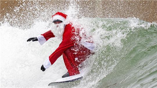 Surflehrer und Rettungsschwimmer Finn Clark aus Gorebridge verkleidet sich als Weihnachtsmann für eine Surfsession im Lost Shore Surf Resort in Newbridge, in der Nähe von Edinburgh.