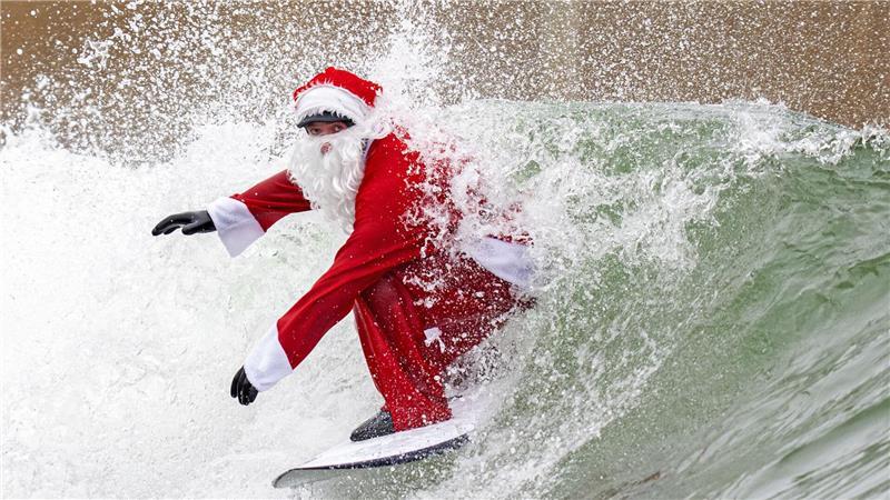 Surflehrer und Rettungsschwimmer Finn Clark aus Gorebridge verkleidet sich als Weihnachtsmann für eine Surfsession im Lost Shore Surf Resort in Newbridge, in der Nähe von Edinburgh.
