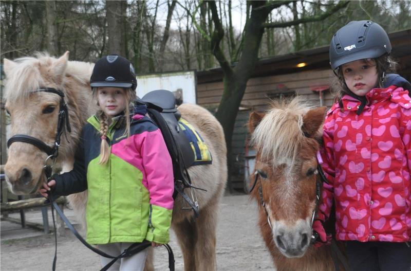Svea (vorne) und Lil müssen ihre Ponys im Reitunterricht um die vielen Pfützen auf dem Gelände herum dirigieren.