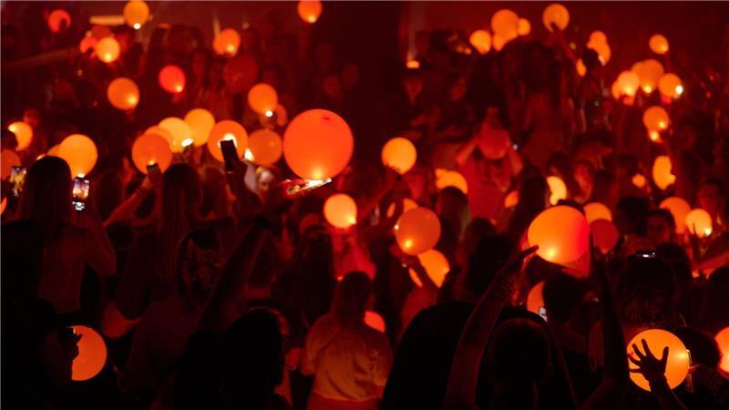 Bilder des Tages „Swifties“ erleuchten in Bochum auf einer Party der Reihe „Taylor Party Europe“ orangefarbene Luftballons mit den Lichtern ihrer Smartphones.