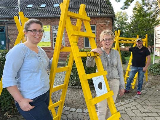Symbol für Optimismus im Einzelhandel - aber auch ein freundliches Warnsignal: Die gelben Leitern zieren demnächst die Wände von Himmelpfortener Selbstständigen. Die Aktion hatte Yvonne Hennig (links) schon lange initiiert. Die ersten Leite